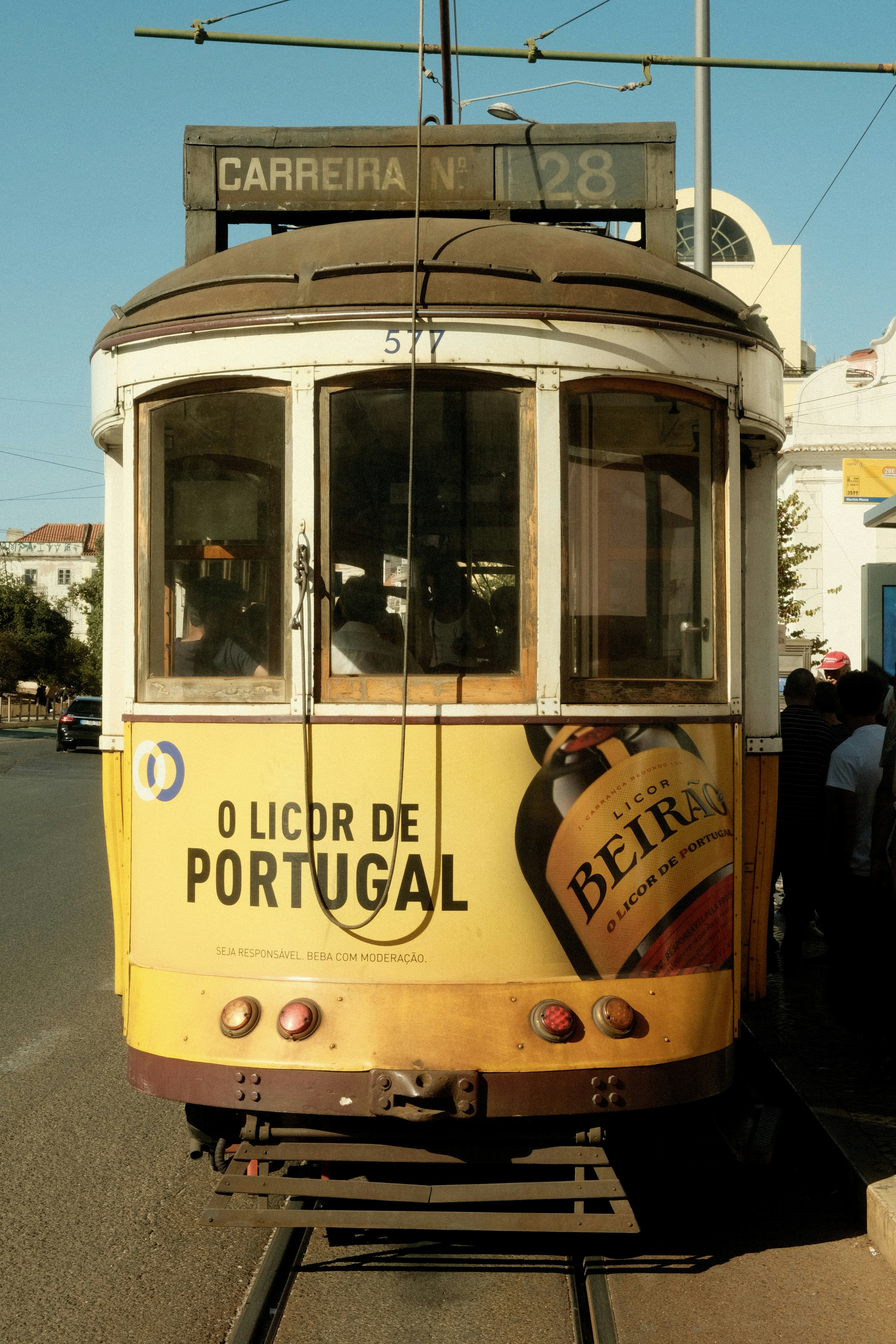 A yellow trolley car on a city street